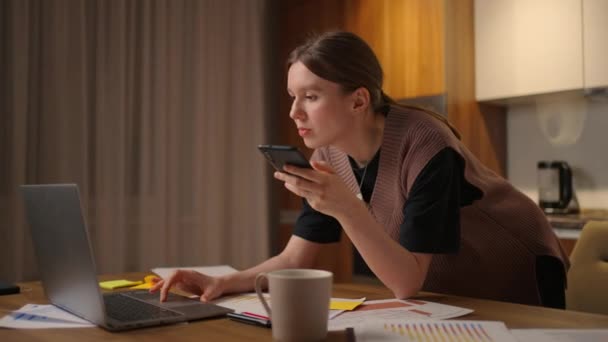 Femme travaillant à la maison, femme d'affaires travaillant sur un ordinateur portable et utilisant un téléphone portable buvant du café assis sur la table dans le jardin le matin. Mode de vie femmes travaillant à la maison concept. — Video