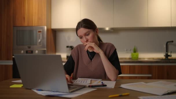Una mujer melancólica mira en un monitor de computadora mientras trabaja desde casa. Crear para inventar. Solución de problemas y lluvia de ideas — Vídeo de stock