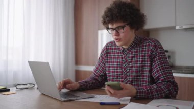 Elinde akıllı telefon olan genç bir adam. Modern iş adamı ya da öğrenci. İşyerinde serbest çalışan biri. Genç bir öğrenci evde dizüstü bilgisayarla ders çalışıyor ve akıllı telefon kullanıyor.