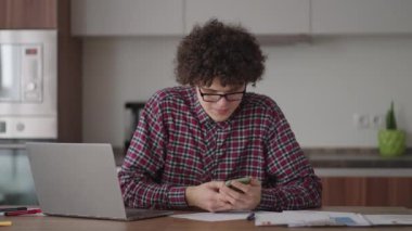 Elinde akıllı telefon olan genç bir adam. Modern iş adamı ya da öğrenci. İşyerinde serbest çalışan biri. Genç bir öğrenci evde dizüstü bilgisayarla ders çalışıyor ve akıllı telefon kullanıyor.