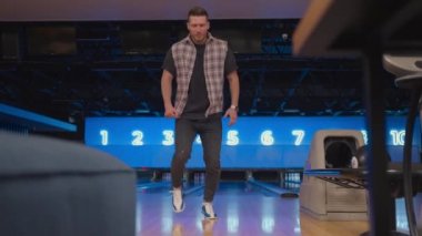 A man dances a victory dance in a bowling club. Celebrating by doing a somersault