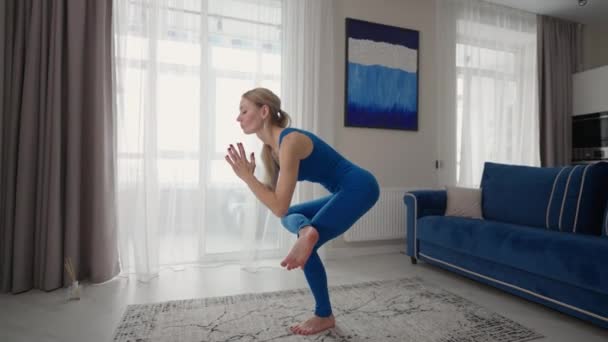 Female performing yoga exercise stretching flexible body lifting hands on mat at home. Sportswoman doing fitness training at living room enjoying physical activity healthy lifestyle — Stockvideo