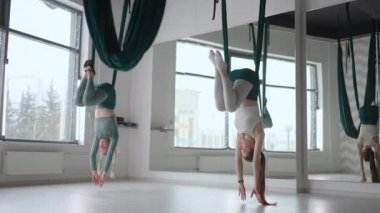 İki kadının iç çekimleri yoga stüdyosunda farklı bir ters yerçekimi yogası uyguluyor. Zihinsel ve fiziksel, iki kişilik çaba ve başarı arasındaki denge