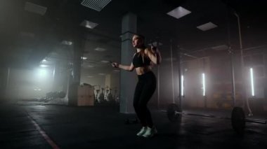 Spor salonunda kadın antrenmanını asmak sağlıklı bir vücut geliştirme. İp atlayan genç bir kadın. Kadın eğitimi, ip atlama, koordinasyon eğitimi.