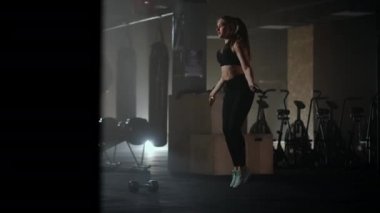 Spor salonunda kadın antrenmanını asmak sağlıklı bir vücut geliştirme. İp atlayan genç bir kadın. Kadın eğitimi, ip atlama, koordinasyon eğitimi.