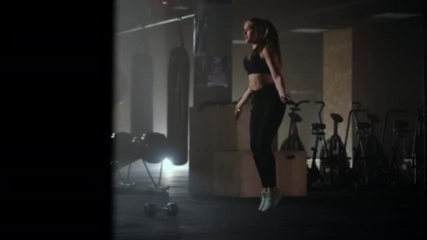 Vrouwentraining in de sportschool overslaan is gezond fitnesslichaam. Een jonge vrouw die touwtjes overslaat. Vrouwentreinen en springtouw, coördinatie training — Stockvideo