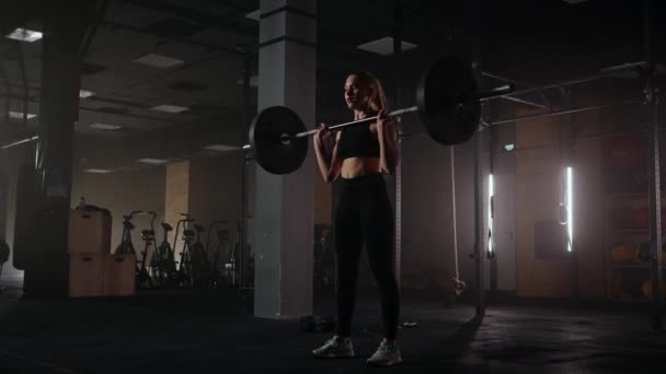 Athlétique belle femme fait Overhead Deadlift avec un haltère dans la salle de gym. Athlète féminine forte avec des poids musculaires de levage du corps, l'exercice avec haltère. femmes faisant de l'exercice avec des poids dans la salle de gym — Video