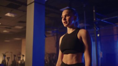 Spor salonunda egzersiz yaptıktan sonra yorgun, spor yaptıktan sonra dinlenen sağlıklı bir kadın. Ferahlatıcı ve canlandırıcı