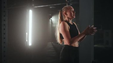 Bir kadının spor salonunda ip tırmanışı yaparken geniş açılı çekimleri. Atletizm sağlıklı kompozisyon. Çapraz fitness. Azimli atletik kadın bir spor salonunda ipe tırmanıyor..