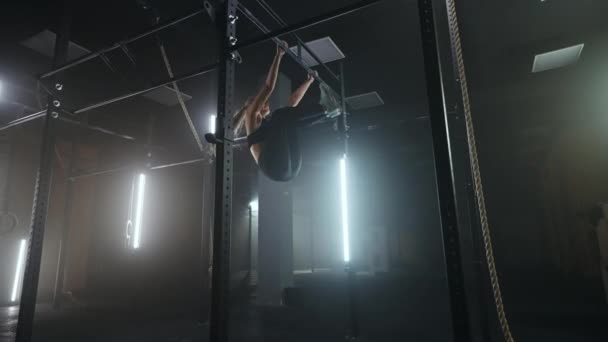 Full längd vidvinkel skott av en kvinna utför rep klättrar på gymmet. Friidrott hälsosam sammansättning. Tvärkondition. Beslutsam atletisk kvinna flyttar upp repet i ett gym. — Stockvideo
