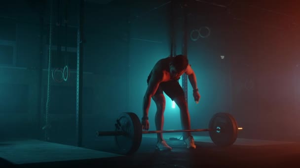 Muskulös fitness man gör skjuta en skivstång över huvudet i moderna fitnesscenter. Funktionell träning. Nattlig övning. Slow motion färg LED-ljus, mättade ljusa färger — Stockvideo