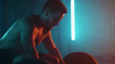 Atletik Üstsüz Adam Eğitimi, Güç Kullanımı, Güç ve Dayanıklılık Halterleri. Ağır çekimde Hardcore Spor Salonu 'nda egzersiz