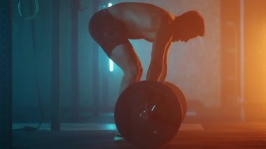 Atletik Üstsüz Adam Eğitimi, Güç Kullanımı, Güç ve Dayanıklılık Halterleri. Ağır çekimde Hardcore Spor Salonu 'nda egzersiz