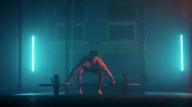 Atletik Üstsüz Adam Eğitimi, Güç Kullanımı, Güç ve Dayanıklılık Halterleri. Ağır çekimde Hardcore Spor Salonu 'nda egzersiz
