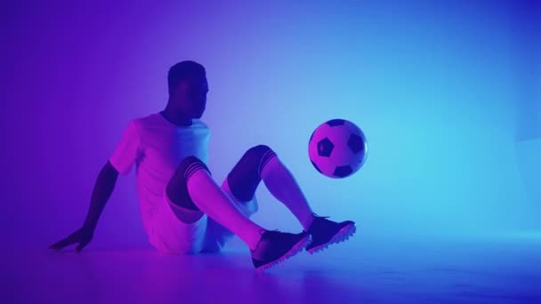 Uomo africano nero Freestyle o calciatore professionista che pratica con pallone da calcio giocoleria sulle gambe, rallentatore. Studio di tiro di un giocatore di calcio professionista con una palla — Video Stock