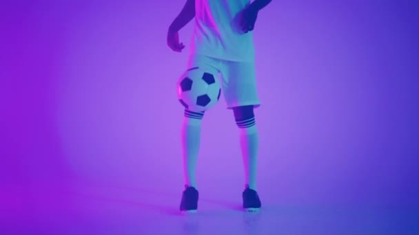 Homme noir africain Freestyle ou footballeur professionnel pratiquant avec ballon de football jonglant sur les jambes, au ralenti. Tournage en studio d'un footballeur professionnel avec un ballon — Video