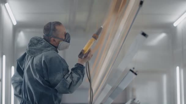 Een professionele schilder in productie in slow motion verft onderdelen — Stockvideo