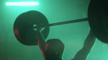 Atletik adam antrenman sırasında spor salonunda halter kaldırıyor. Halter halter ağırlık kaldırma egzersizi kullanarak vücut geliştirme eğitimi. Kararlı kaslı adam ağır ağırlık kaldırıyor.