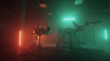 Bir erkek ve bir kadın spor salonunda vücut gerdirme egzersizleri yapıyorlar. İki insan göbek egzersizi yapar.