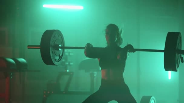 Slow motion: Athletic Beautiful Woman Does Overhead Deadlift with a Barbell in the Gym. Femeie culturist profesionist antrenament exerciții de ridicare a greutății în facilitatea autentică de formare sportivă. — Videoclip de stoc