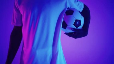 Stüdyoda, bir futbol oyuncusunun ayağının altındaki futbol topunu yavaş çekimde yaklaş. Stüdyoda topu olan profesyonel bir futbolcu.