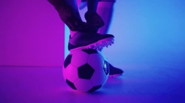 Stüdyoda, bir futbol oyuncusunun ayağının altındaki futbol topunu yavaş çekimde yaklaş. Stüdyoda topu olan profesyonel bir futbolcu.