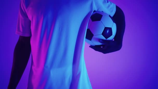 Крупный план футбольного мяча у ног футболиста в студии в замедленной съемке. Профессиональный футболист с мячом в студии — стоковое видео
