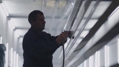 Çelik yapılar üreten adamlar boya atölyesinde boya yapmak için parça hazırlıyorlar.