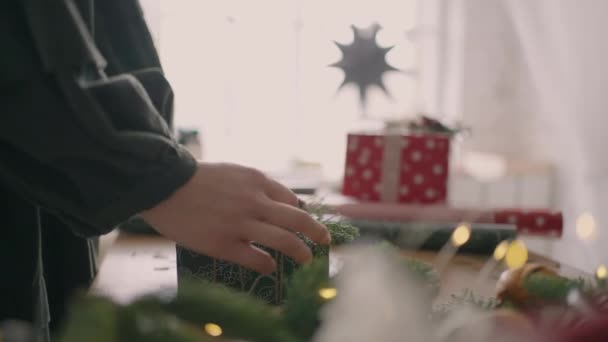 A woman hands over a packaged gift. Buying a gift. Garlands and lights — Stock Video