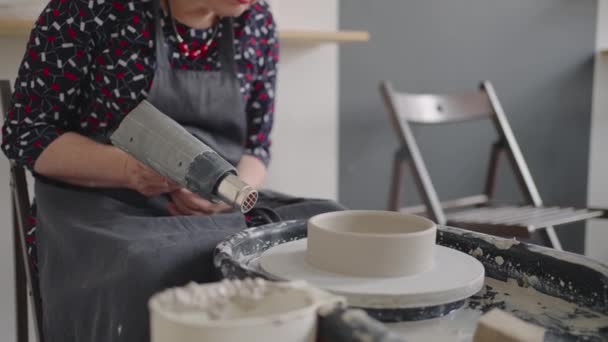 Asciugare un bianco di ceramica per i piatti con un asciugacapelli. Laboratorio di ceramica — Video Stock