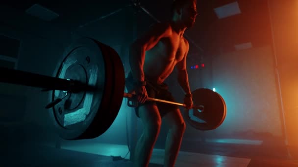 Brawny powerlifter je trénink v tělocvičně, zvedání činky v tmavé hale, vytrvalost a motivace — Stock video