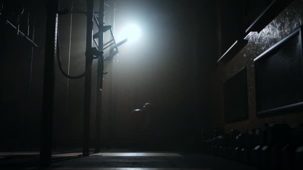 Entraînement physique dans la salle de gym la nuit, la femme joue avec une grosse balle, silhouette prise dans l'obscurité — Video