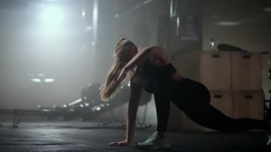 Genç ince kadın spor salonunda, yoga ve spor salonunda fiziksel egzersiz yapıyor.