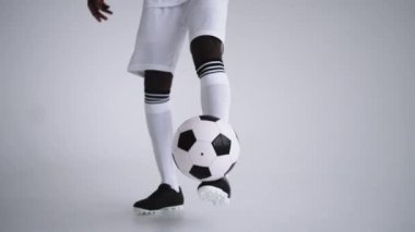 Futbol topunun yukarısında, oyuncuların ayaklarının tekmelenmesi ve topu tutması, teknik beceri.