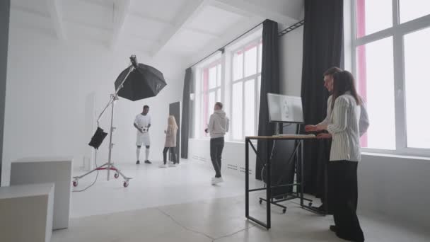 Sportif photoshoot untuk majalah, produser berbicara dengan pemain sepak bola model di studio — Stok Video