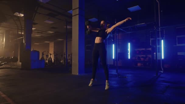 Entrenamiento de potencia en el gimnasio, la mujer está levantando la mancuerna en el gimnasio, entrenamiento solo en la noche — Vídeo de stock
