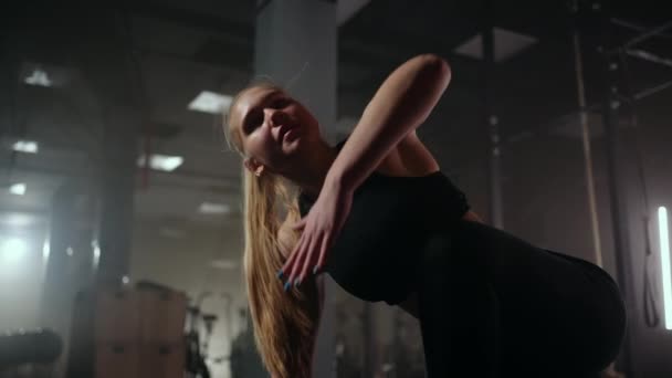Προπόνηση φυσικής κατάστασης στο γυμναστήριο, νεαρή σπορ γυναίκα θερμαίνει το σώμα πριν από τη σκληρή άσκηση για τον αθλητικό εξοπλισμό — Αρχείο Βίντεο
