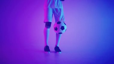 Kendine güvenen ve yetenekli Afrikalı futbolcu stüdyoda top sürüyor, futbolcu portresi.