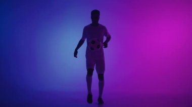 Profesyonel futbolcu topla tekme atıyor ve onu yakalıyor, Afrikalı bir adamın portresi.