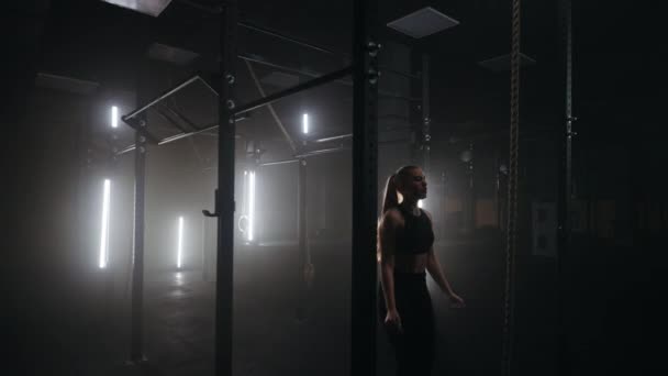 Atletische vrouw is het trainen op crossbar in de sportschool, zwaaien en tillen benen, spannen buikspieren en beenspieren — Stockvideo