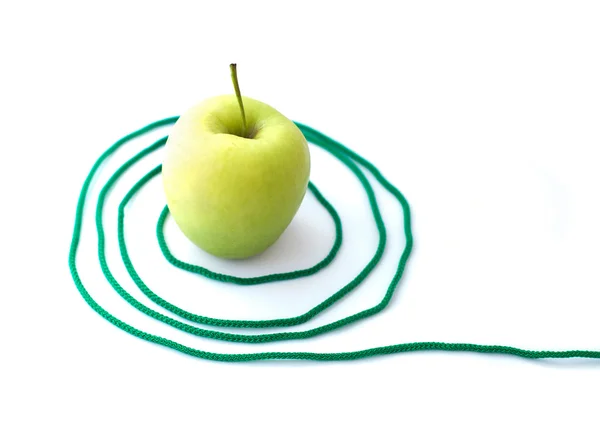 Зеленое яблоко с веревкой — стоковое фото