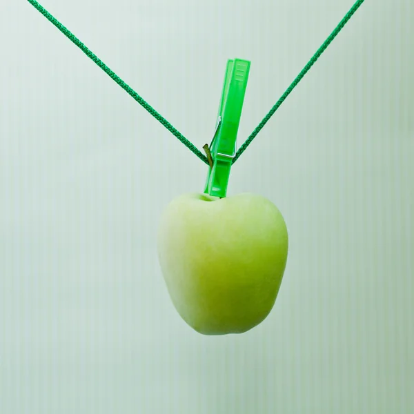 Green apple hanging on the rope — Stock Photo, Image