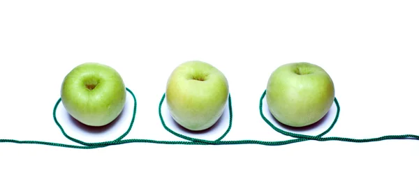 Grüne Äpfel in einer Reihe mit Seil — Stockfoto