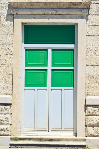 고 대 벽에 녹색 문 — 스톡 사진