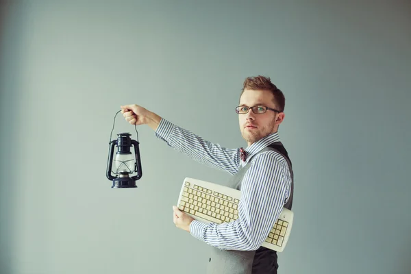 Joven hombre de la computadora en traje sostiene el teclado y el candelero —  Fotos de Stock