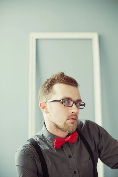Young man in eyeglasses, red bowtie and suspenders — Stock Photo, Image