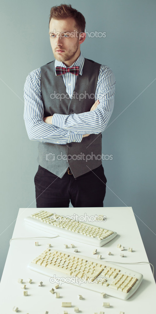 Young man near the table with computer keyboards
