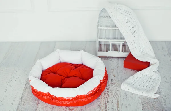 Matelas rouge pour animaux de compagnie dans la chambre avec cage — Photo