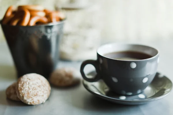 Xícara com chá preto e bolos — Fotografia de Stock