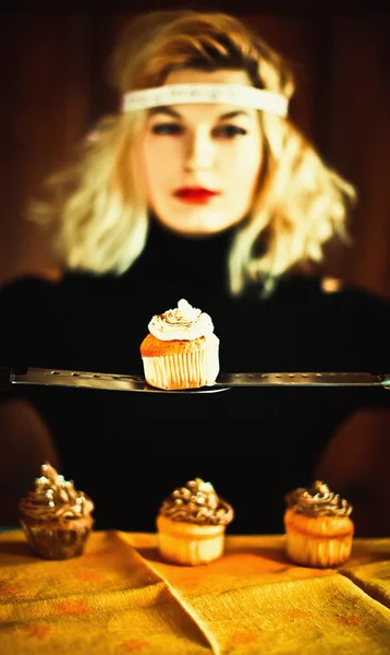 Vintage femme au foyer blonde et cupcakes avec des couteaux — Photo